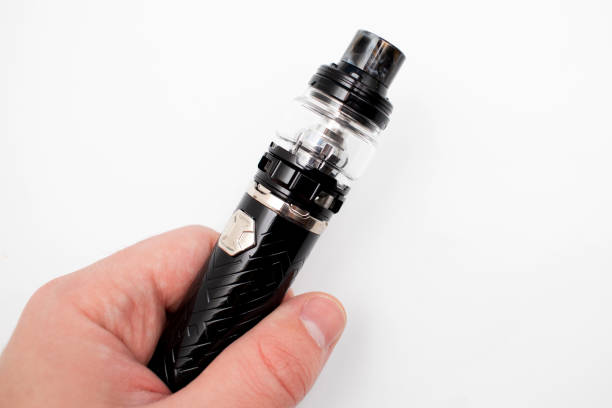 Electronic cigarette in mens hand.